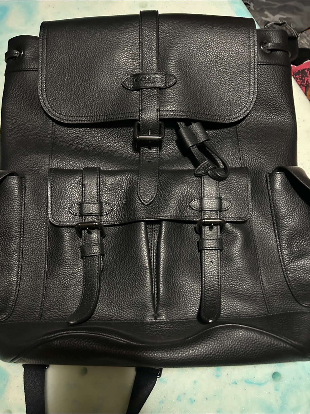Coach Black Pebbled Leather Backpack with Front Buckle Pockets.